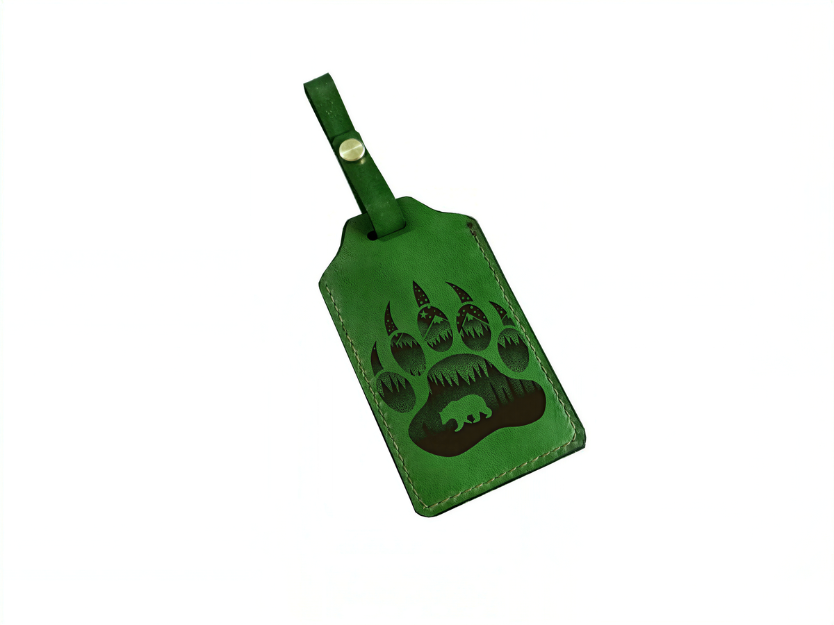 A green luggage tag with a bear paw print design printed on it.